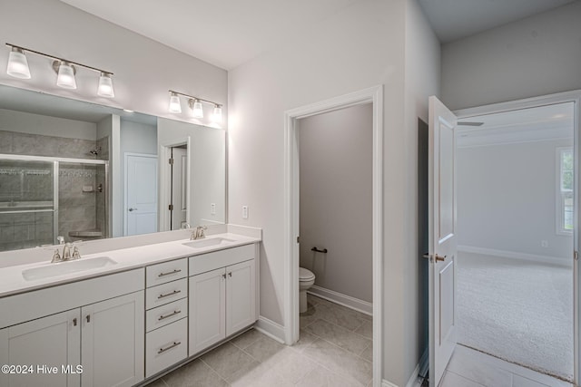 bathroom with toilet, a shower with door, vanity, and tile patterned flooring