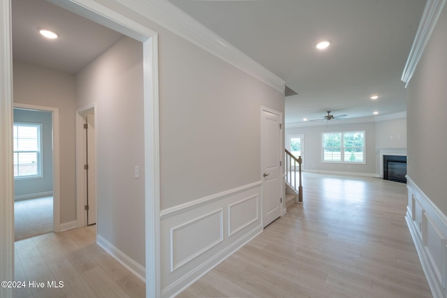 hall with crown molding and light hardwood / wood-style flooring