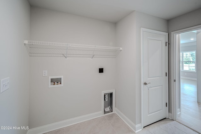 clothes washing area featuring washer hookup, electric dryer hookup, and light tile patterned flooring