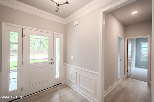 foyer entrance featuring light hardwood / wood-style flooring and ornamental molding