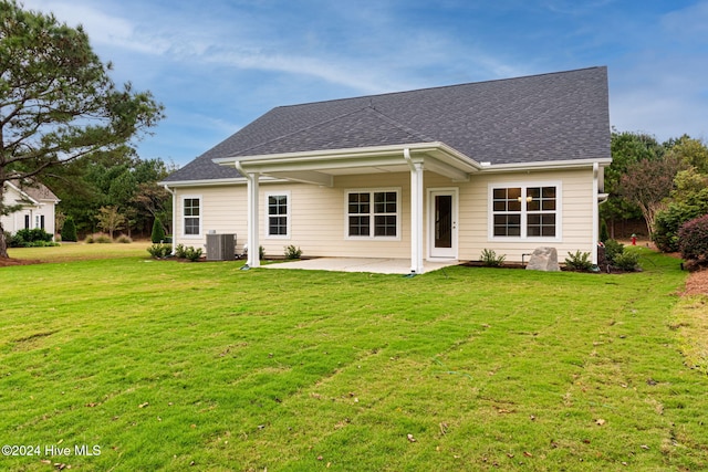 rear view of house with a yard, a patio, and cooling unit