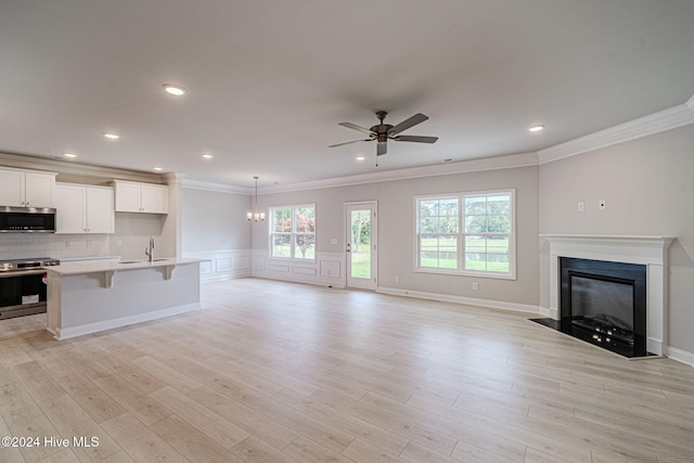 interior space with ceiling fan with notable chandelier, sink, crown molding, and light hardwood / wood-style flooring