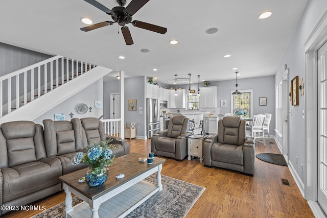 living room with light hardwood / wood-style floors and ceiling fan