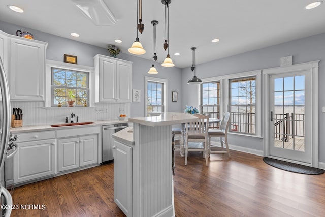 kitchen featuring pendant lighting, a center island, tasteful backsplash, dishwasher, and dark hardwood / wood-style flooring