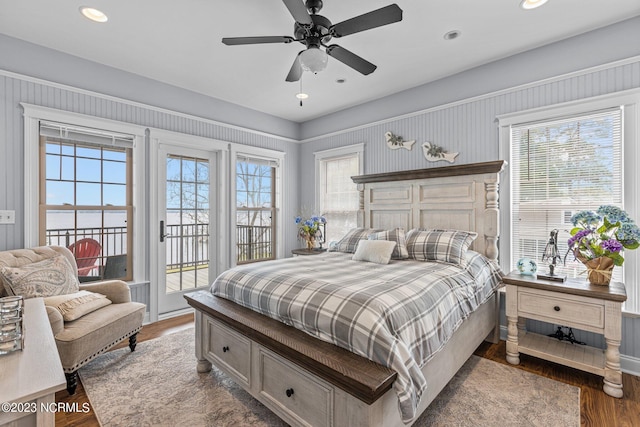 bedroom with multiple windows, access to exterior, ceiling fan, and hardwood / wood-style flooring