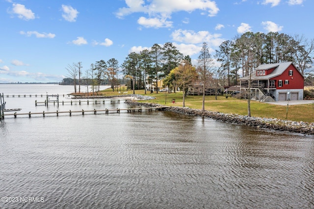 view of dock featuring a lawn and a water view