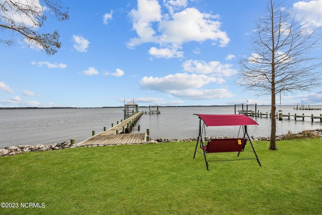 dock area with a water view and a lawn