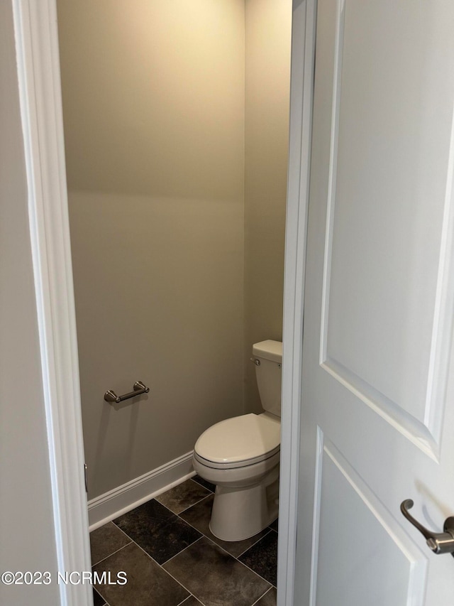 bathroom with toilet and baseboards