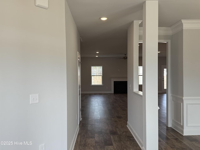 hallway with dark wood-style flooring, recessed lighting, ornamental molding, wainscoting, and baseboards