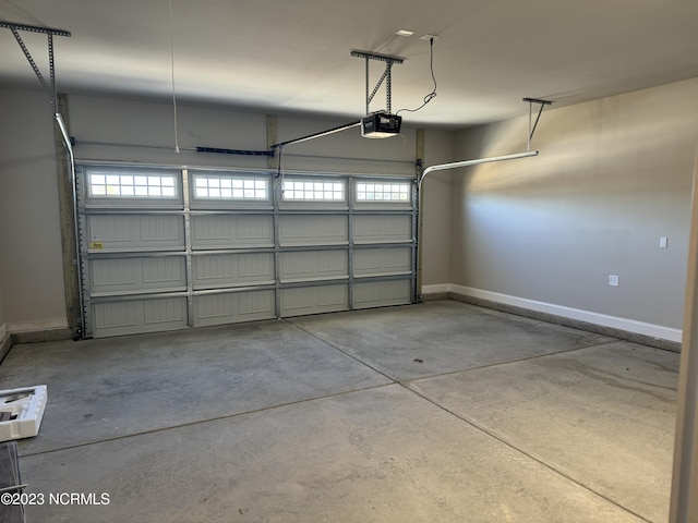 garage featuring a garage door opener and baseboards