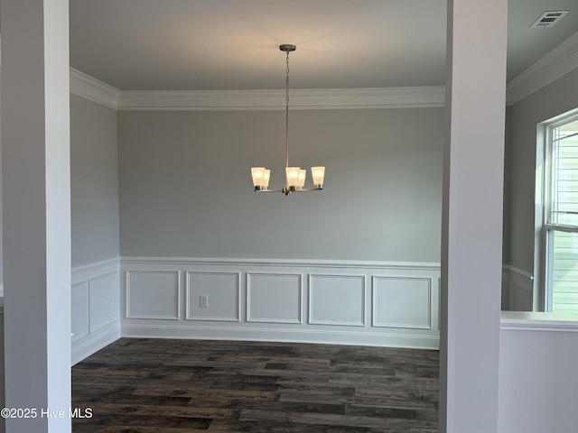 unfurnished dining area with dark wood-style flooring, visible vents, ornamental molding, wainscoting, and a chandelier