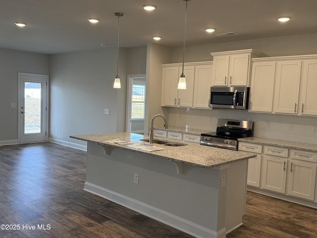 kitchen featuring a kitchen island with sink, appliances with stainless steel finishes, a sink, and white cabinetry