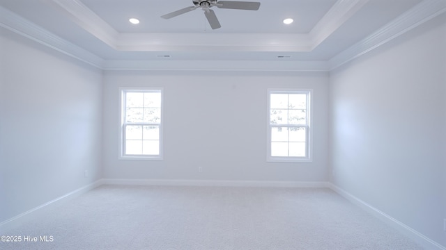 spare room featuring baseboards, a raised ceiling, a ceiling fan, and light colored carpet