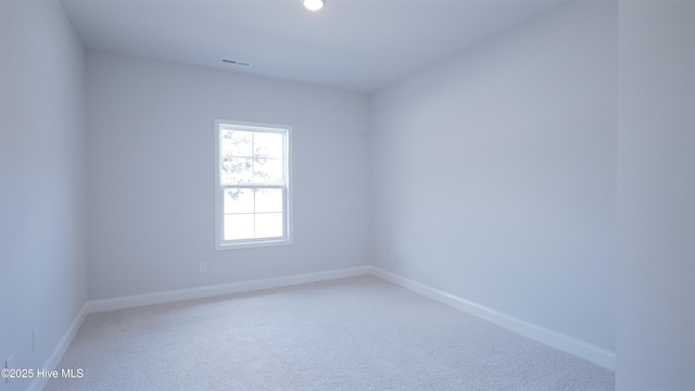 carpeted spare room with visible vents and baseboards