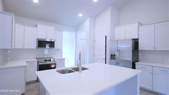 kitchen featuring appliances with stainless steel finishes, white cabinets, and a sink