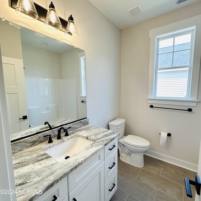 bathroom featuring vanity, toilet, and tile patterned flooring