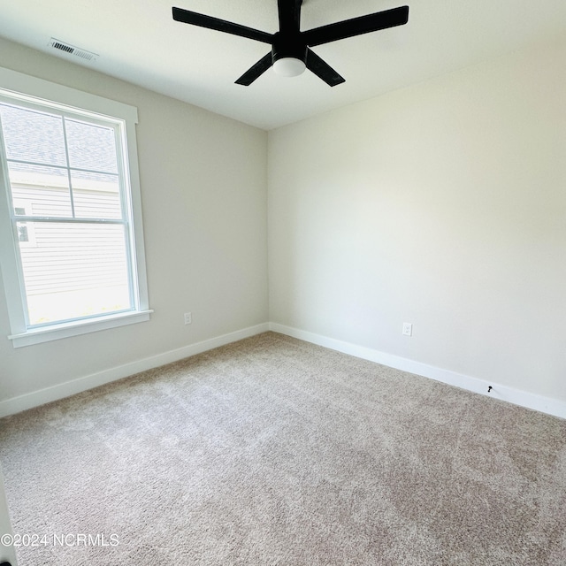 carpeted spare room featuring ceiling fan