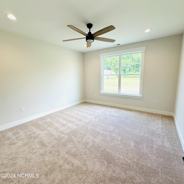 spare room with light carpet and ceiling fan