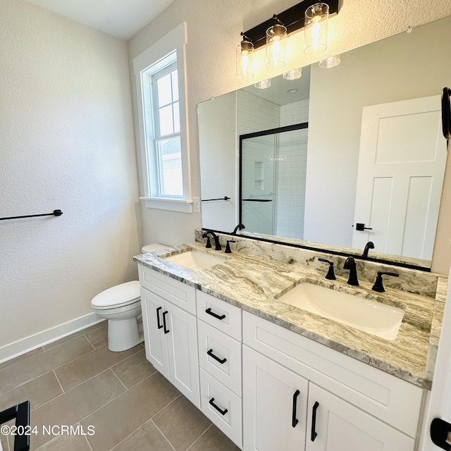 bathroom featuring tile patterned flooring, toilet, and dual bowl vanity