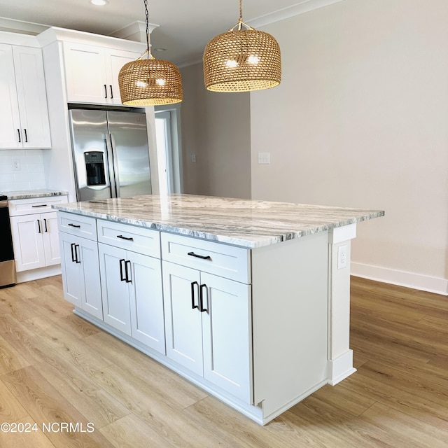 kitchen featuring decorative light fixtures, white cabinetry, stainless steel fridge with ice dispenser, light wood-type flooring, and a center island