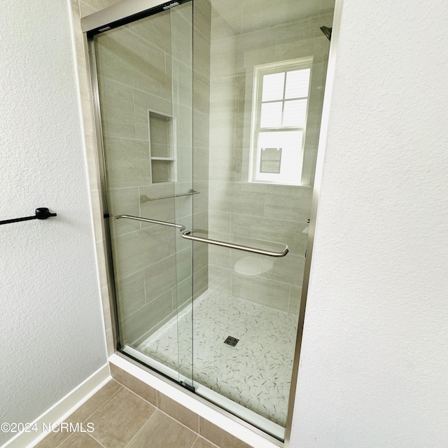 bathroom with a shower with door