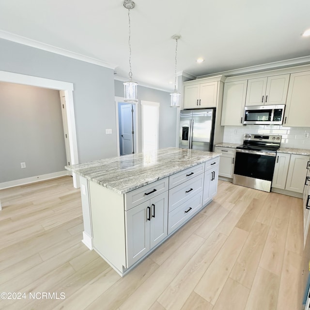 kitchen featuring appliances with stainless steel finishes, light hardwood / wood-style flooring, decorative backsplash, a center island, and ornamental molding