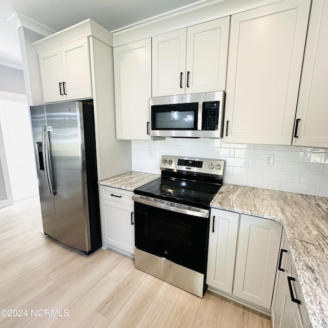 kitchen with light hardwood / wood-style flooring, decorative backsplash, and stainless steel appliances