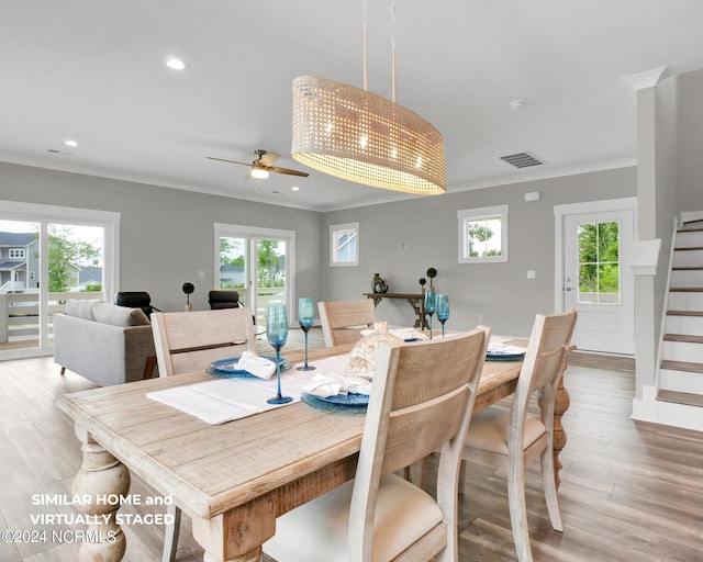 dining space featuring plenty of natural light, visible vents, crown molding, and stairway