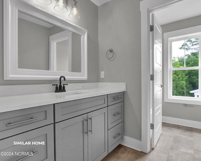 bathroom with tile patterned floors, baseboards, and vanity