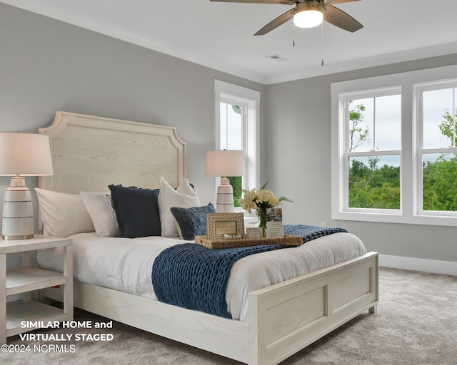 carpeted bedroom featuring multiple windows, baseboards, and a ceiling fan