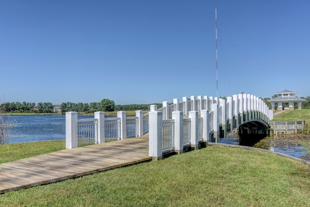 dock area featuring a lawn and a water view