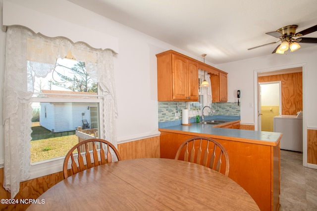 tiled dining room with ceiling fan, sink, washer / dryer, and a wealth of natural light