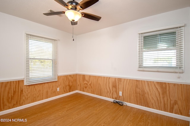 unfurnished room featuring ceiling fan, light wood-type flooring, and plenty of natural light