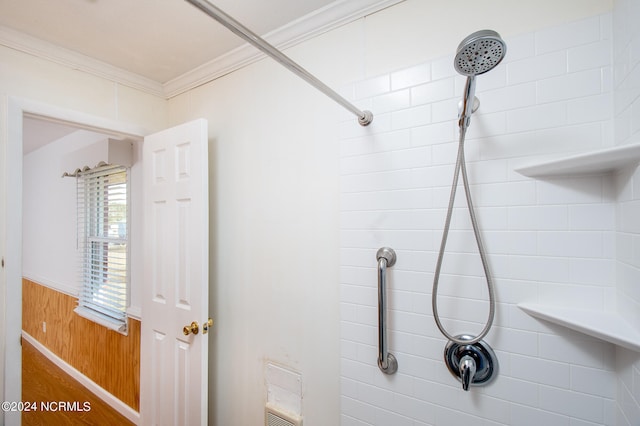 interior details featuring ornamental molding and tiled shower