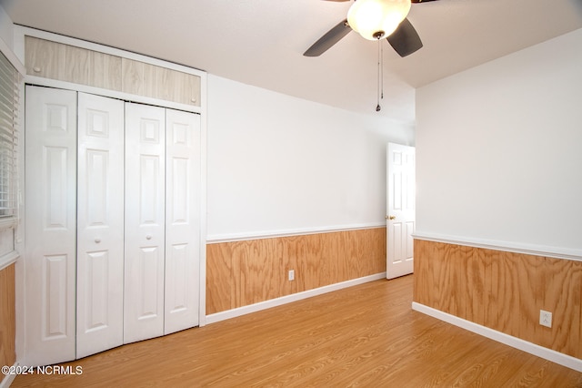 unfurnished bedroom featuring a closet, light hardwood / wood-style floors, and ceiling fan