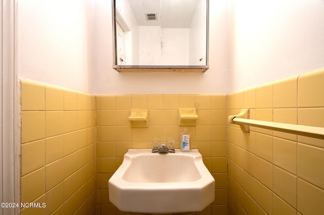 bathroom with tile walls, tasteful backsplash, and sink