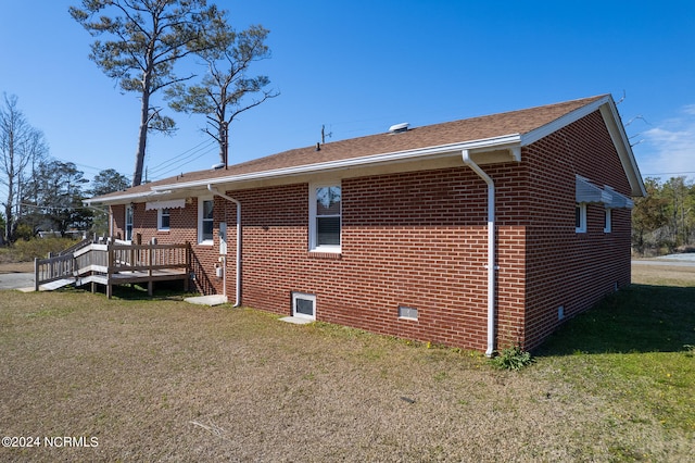 view of front facade with a wooden deck and a front yard