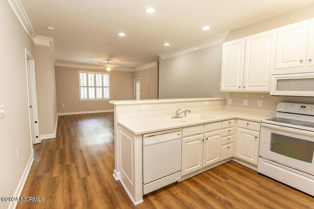 kitchen with white appliances, dark hardwood / wood-style flooring, ceiling fan, sink, and kitchen peninsula