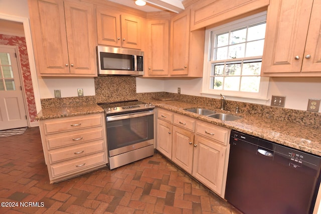 kitchen featuring sink, stainless steel appliances, backsplash, and light stone counters