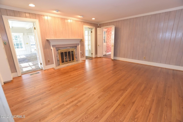 unfurnished living room featuring crown molding and light wood-type flooring