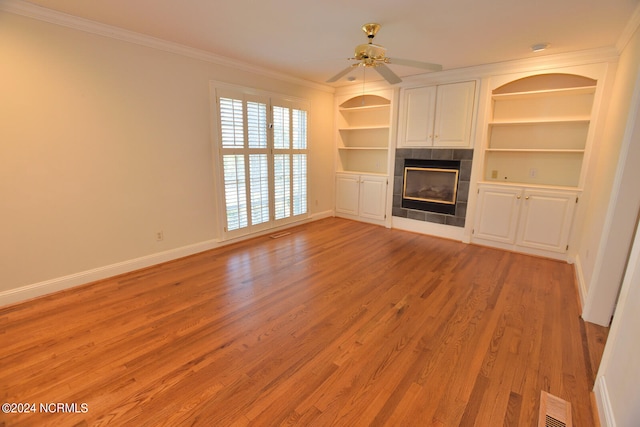 unfurnished living room with ceiling fan, ornamental molding, light hardwood / wood-style flooring, and a fireplace