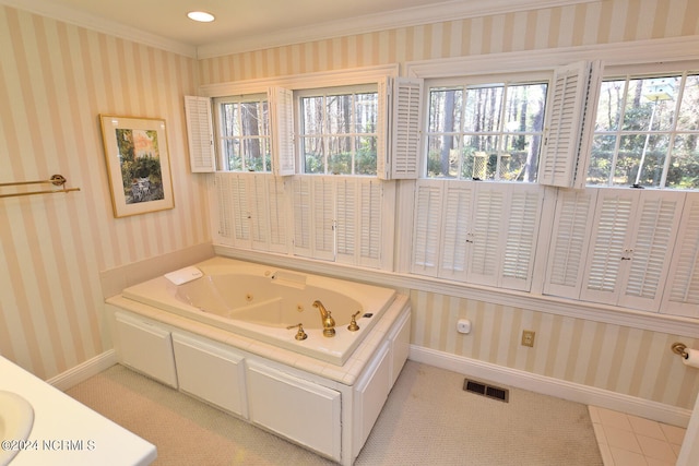 bathroom with a healthy amount of sunlight, a bath, and crown molding