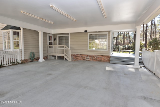 unfurnished sunroom with decorative columns