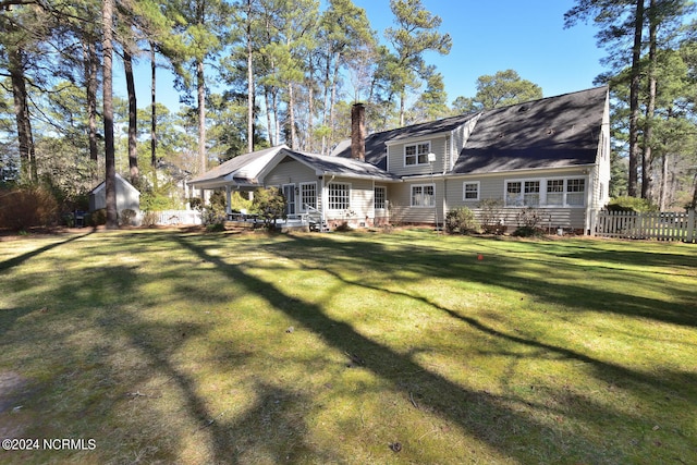 back of property featuring a lawn and an outdoor structure