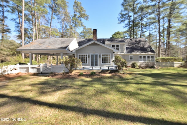 rear view of house featuring a lawn