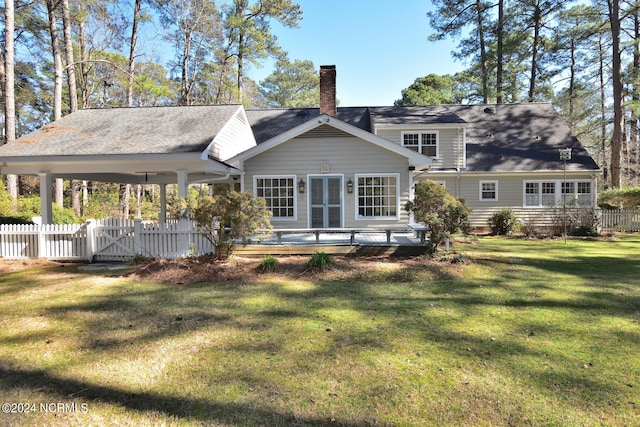 back of property featuring a lawn and a wooden deck