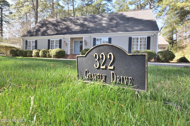 community / neighborhood sign featuring a lawn