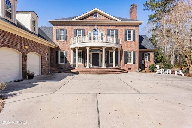 colonial home featuring a balcony and a garage