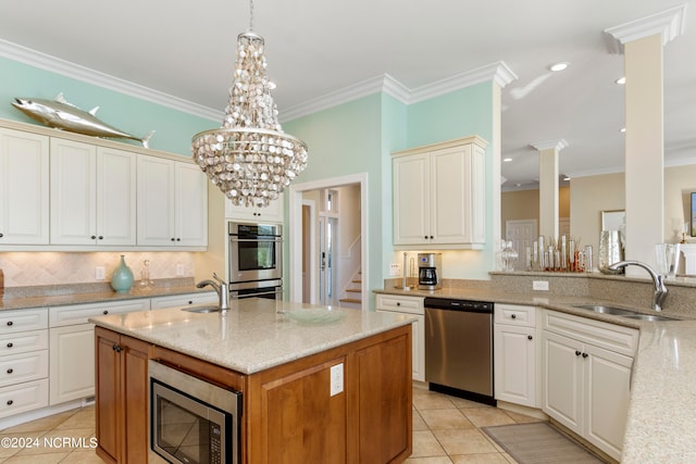 kitchen with light tile floors, stainless steel appliances, pendant lighting, light stone countertops, and sink