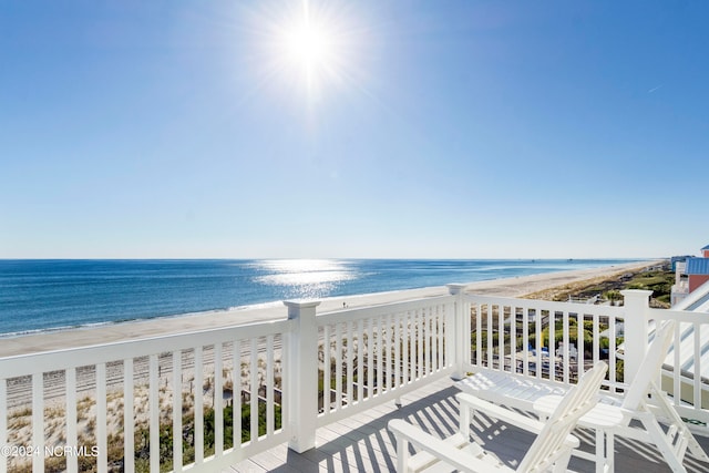 balcony with a water view and a view of the beach